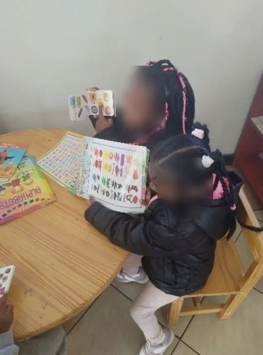 Two girls holding up their picture books