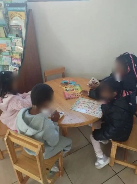 Preschoolers looking at books at a round table